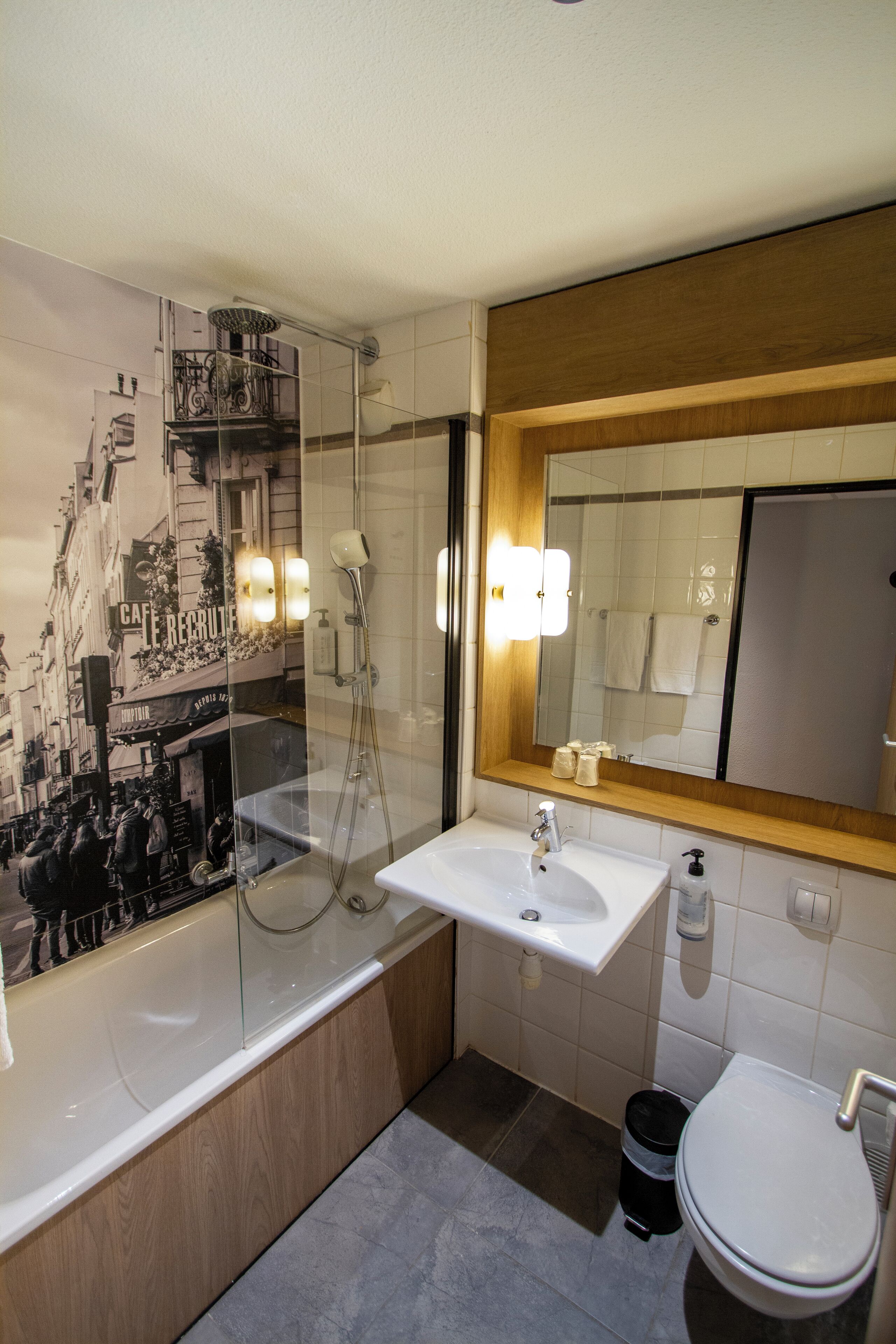 Une salle de bain moderne avec une douche à parois de verre, un lavabo blanc et des toilettes.