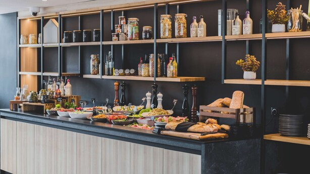 Un'area buffet con diversi cibi, condimenti e bevande.