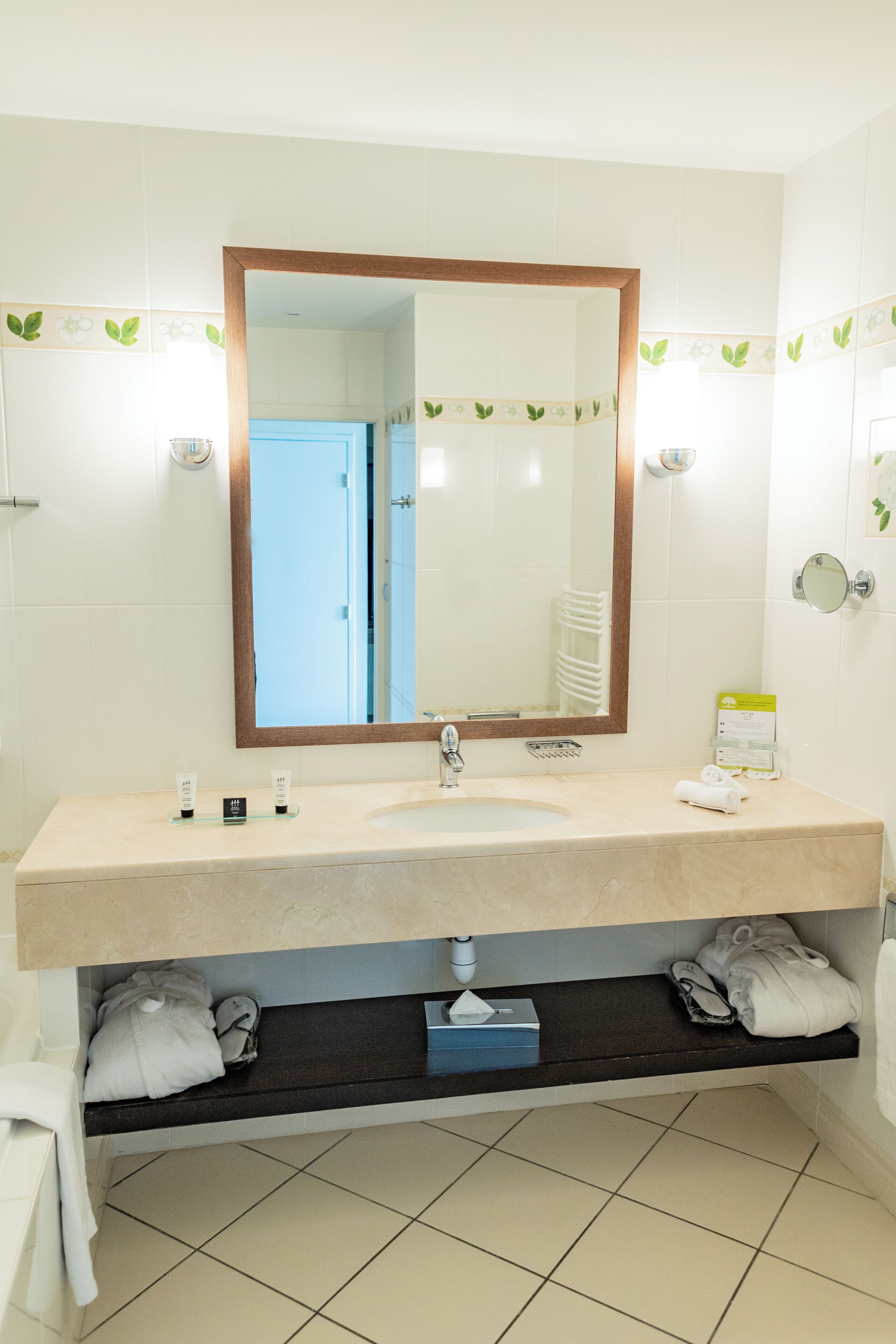 Une salle de bain avec un lavabo beige, un miroir et un porte-serviettes.