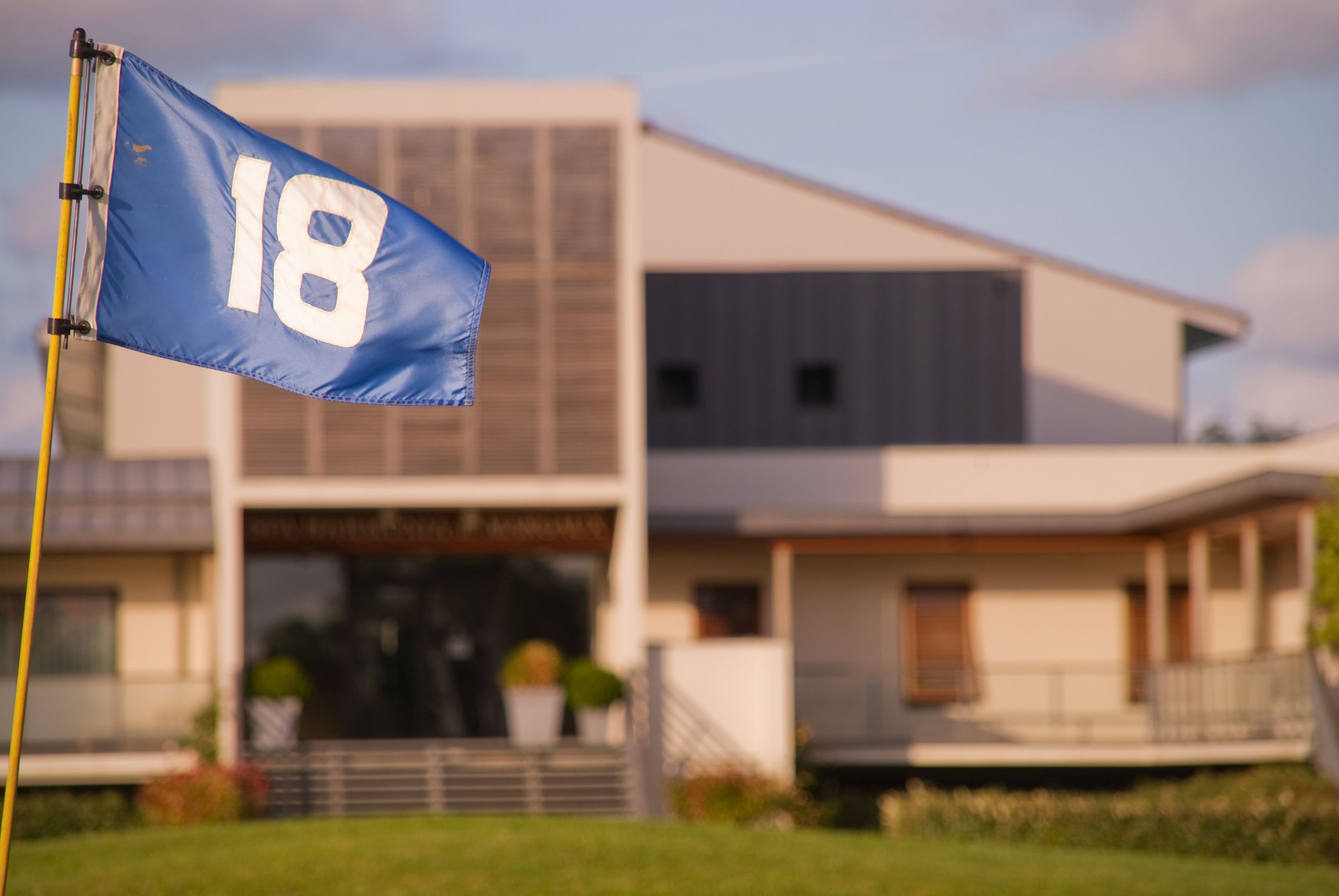 Un edifici modern amb una bandera que mostra el número 18.