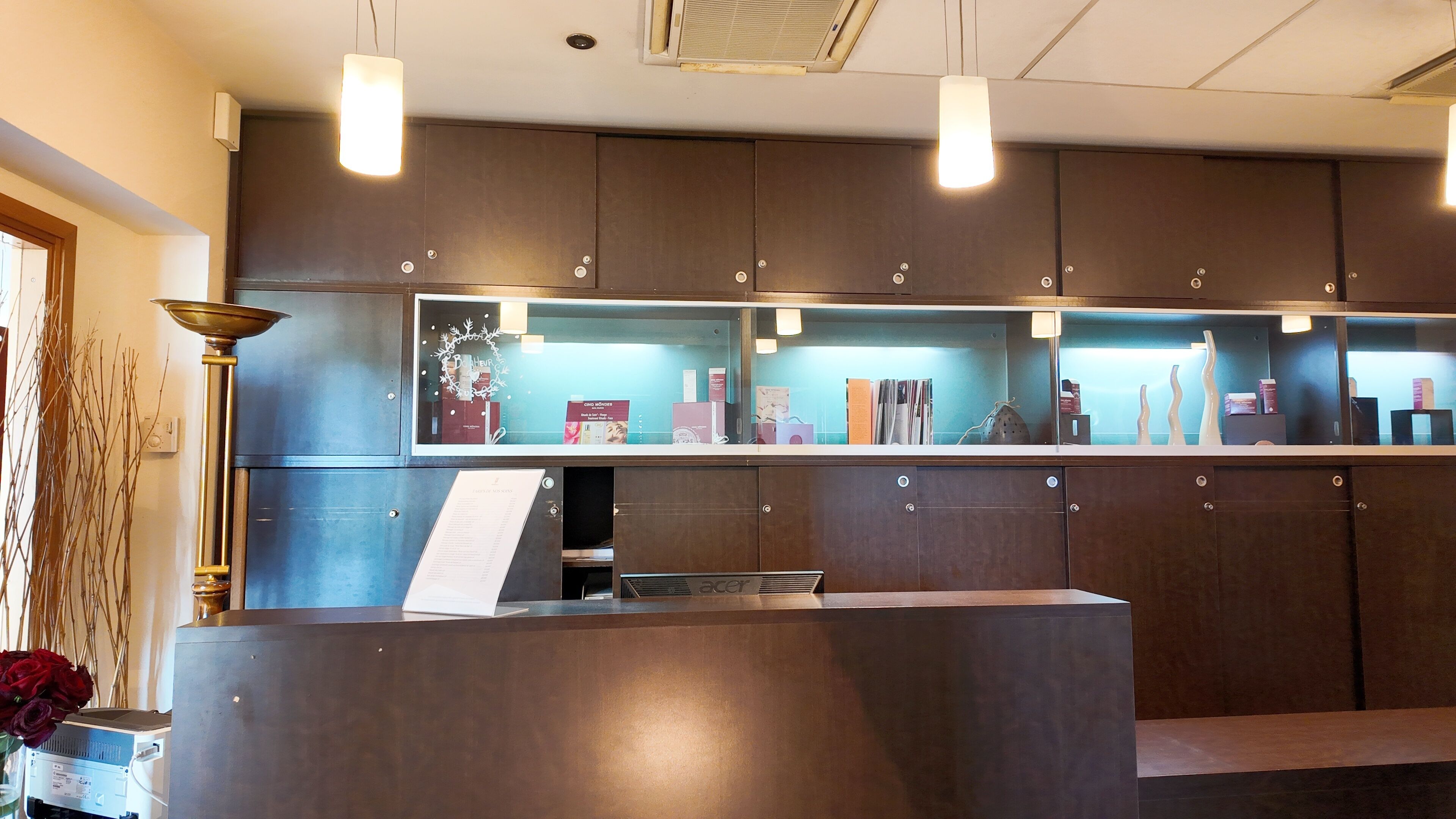 A reception desk with a glass display case containing magazines and books.