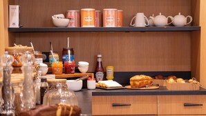 A kitchen counter with various food items, jars, and kitchenware.