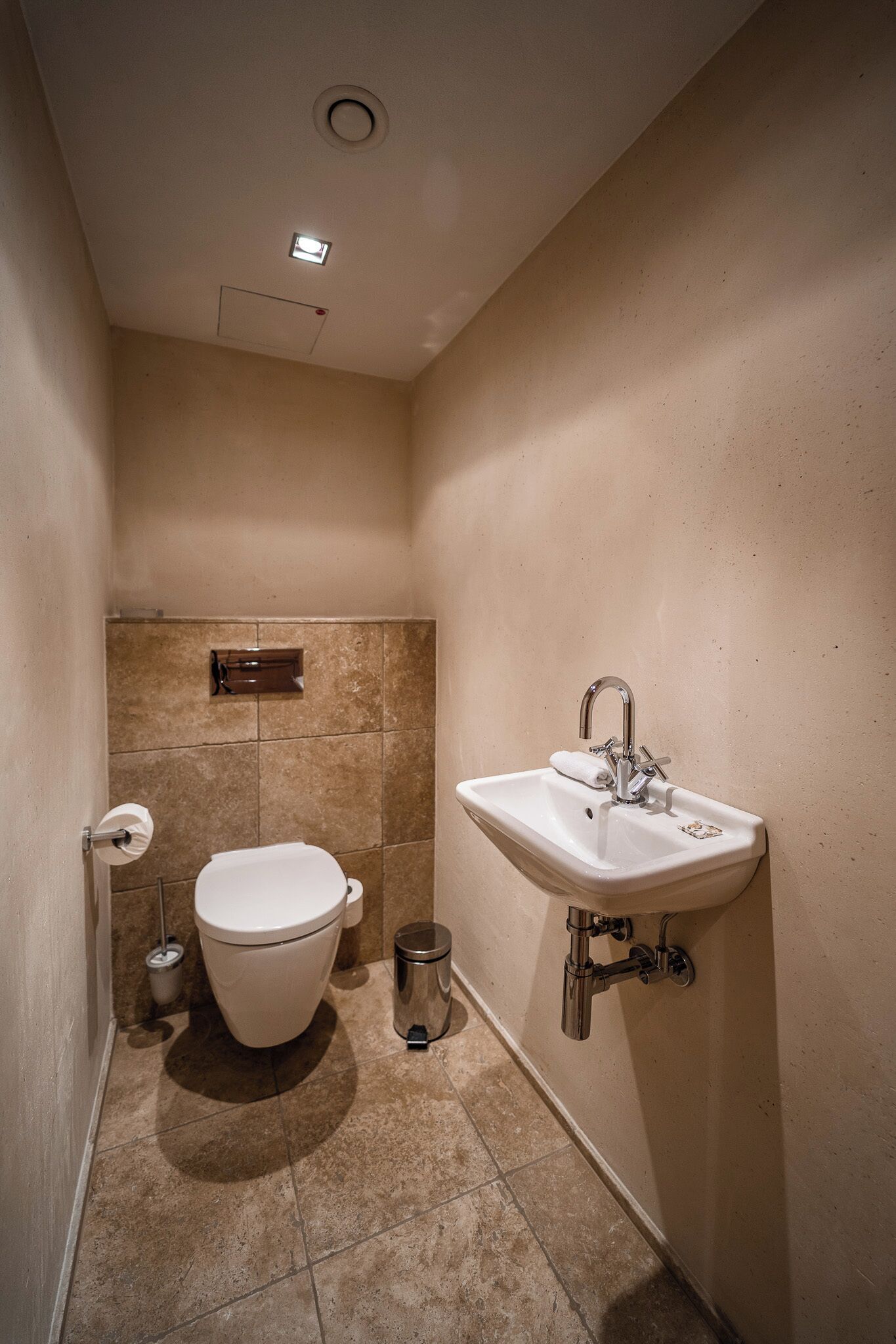Une salle de bain avec des toilettes, un lavabo et une poubelle.