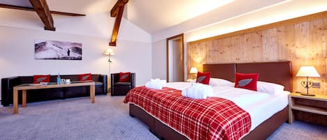 A hotel room with a large bed, a wooden headboard, a desk, and a chair.