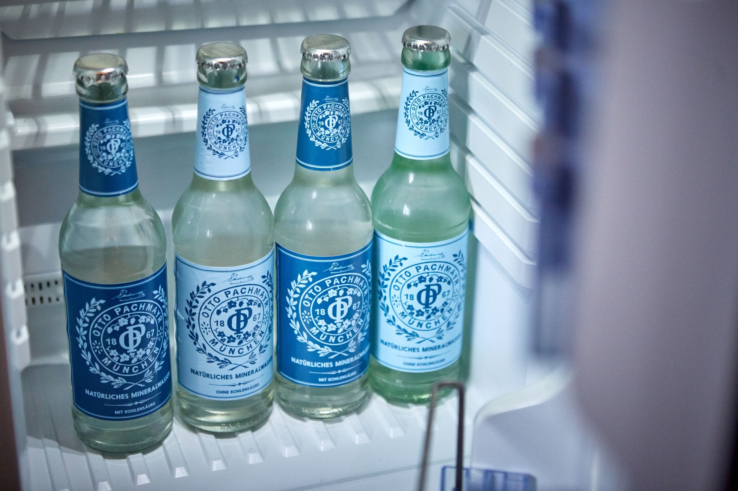 Ein Kühlschrank mit vier Bierflaschen mit Etiketten.