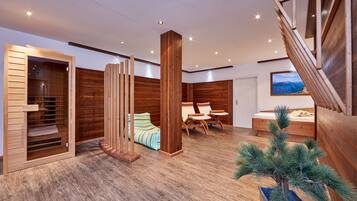 Ein modernes Interieur mit Holzboden, einem Bett mit Blick, einer Sitzecke und einer Treppe.