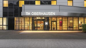 Fachada moderna de un hotel con el nombre "TH Oberhausen" bien visible.