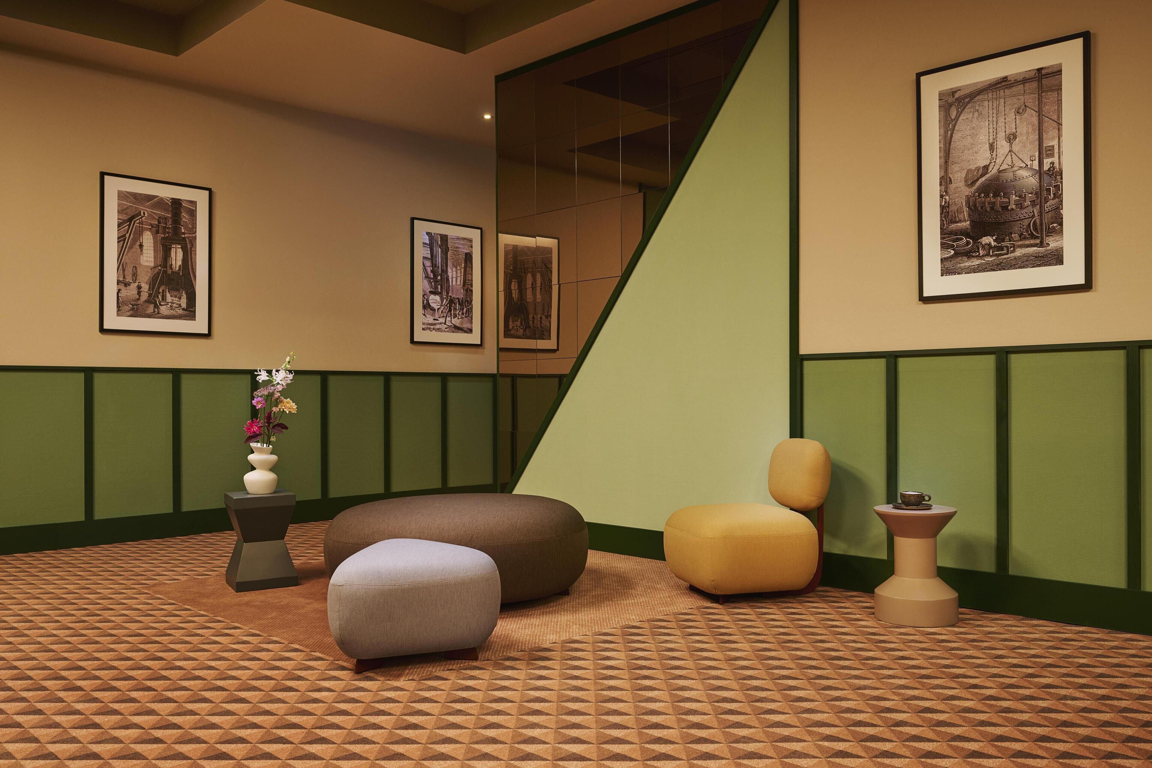 A room with geometric patterned carpet, a green and beige color scheme, and a staircase.