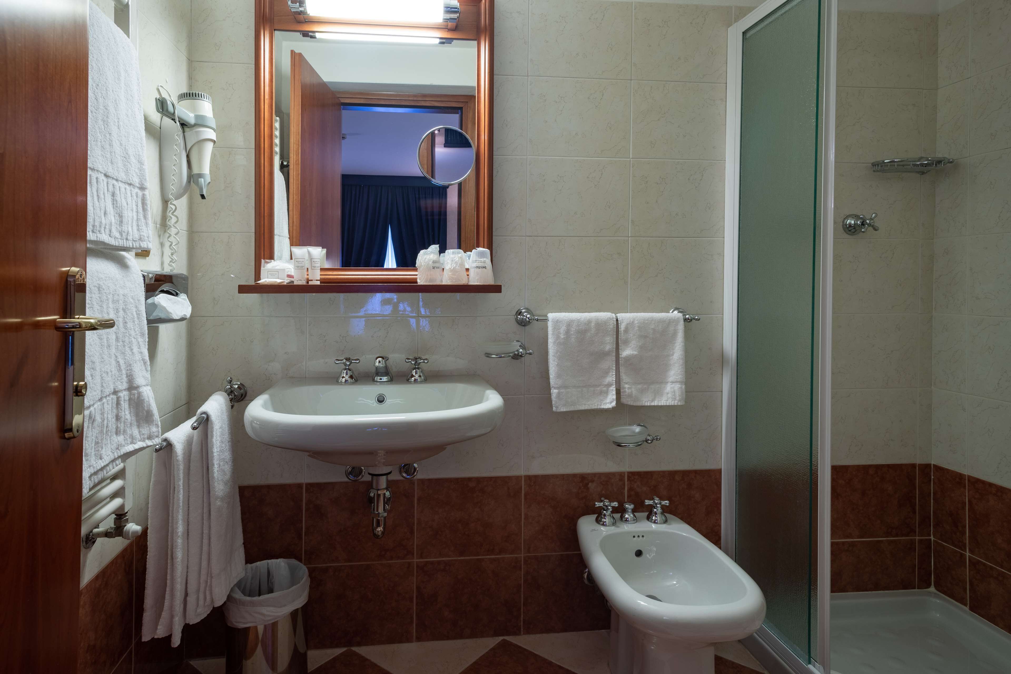 Un baño con lavamanos, bidé y espejo.