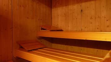 Uma sauna com bancos de madeira e parede de madeira.