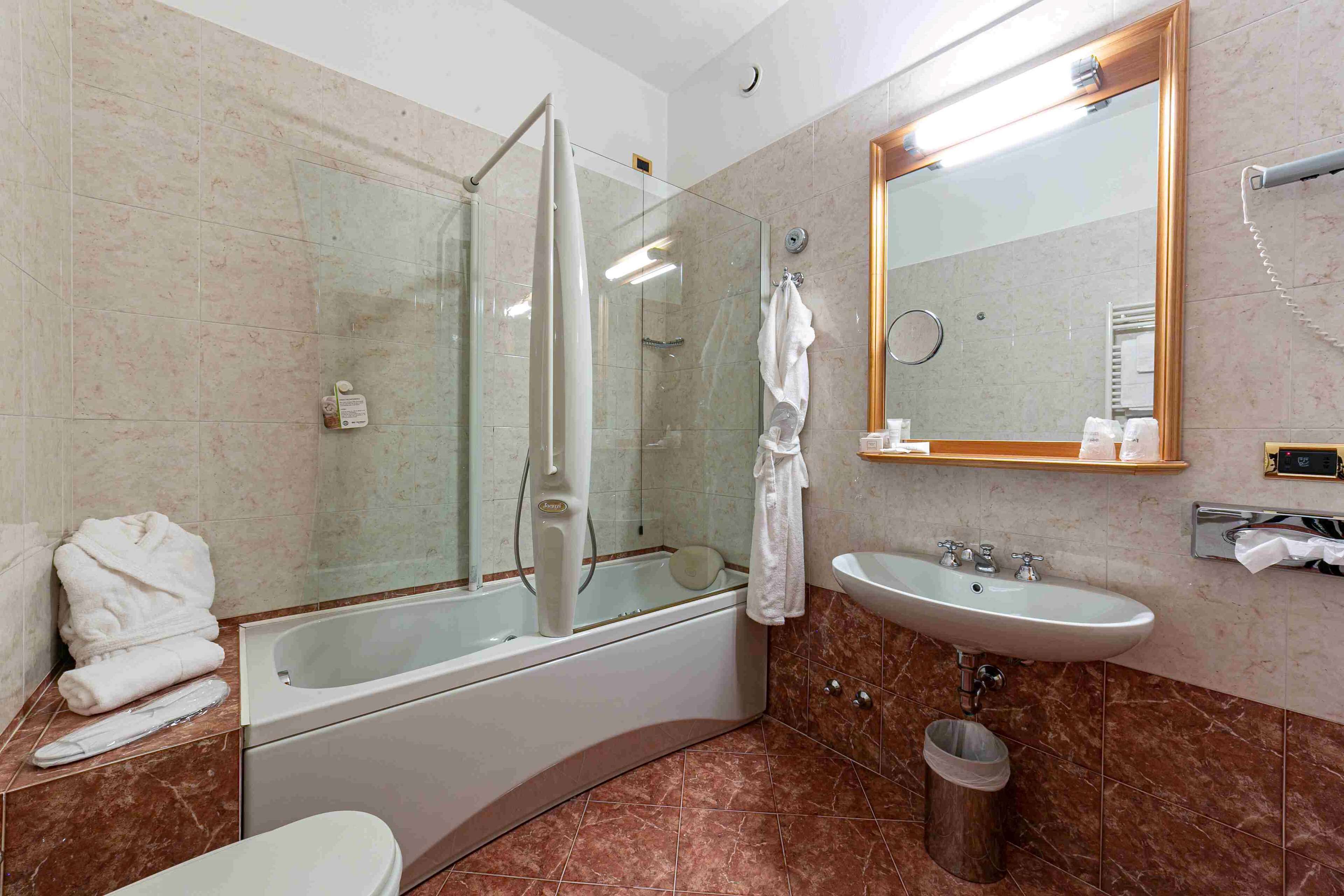 Un baño moderno con ducha de vidrio, bañera, lavabo e inodoro.