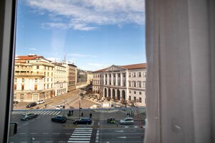 Una strada cittadina con edifici, un attraversamento pedonale e veicoli.