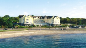 A large hotel with multiple stories, a prominent glass facade, and a waterfront location.