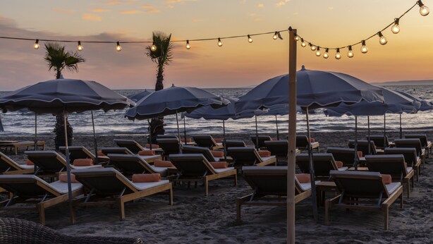 A beachside lounge area with rows of sun loungers and umbrellas, overlooking the ocean. - Hôtel & Spa - Thalazur Port Camargue (Le Grau-Du-Roi)