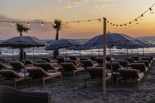 Praia particular, espreguiçadeiras, guarda-sóis, toalhas de praia 