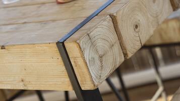 Una mesa de madera con patas metálicas y un tarro de mermelada.