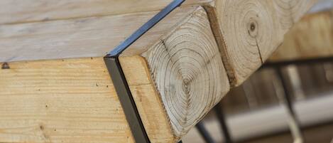 Een houten tafel met metalen poten en een potje jam.