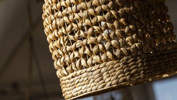 A woven hanging light fixture with a cylindrical shape.