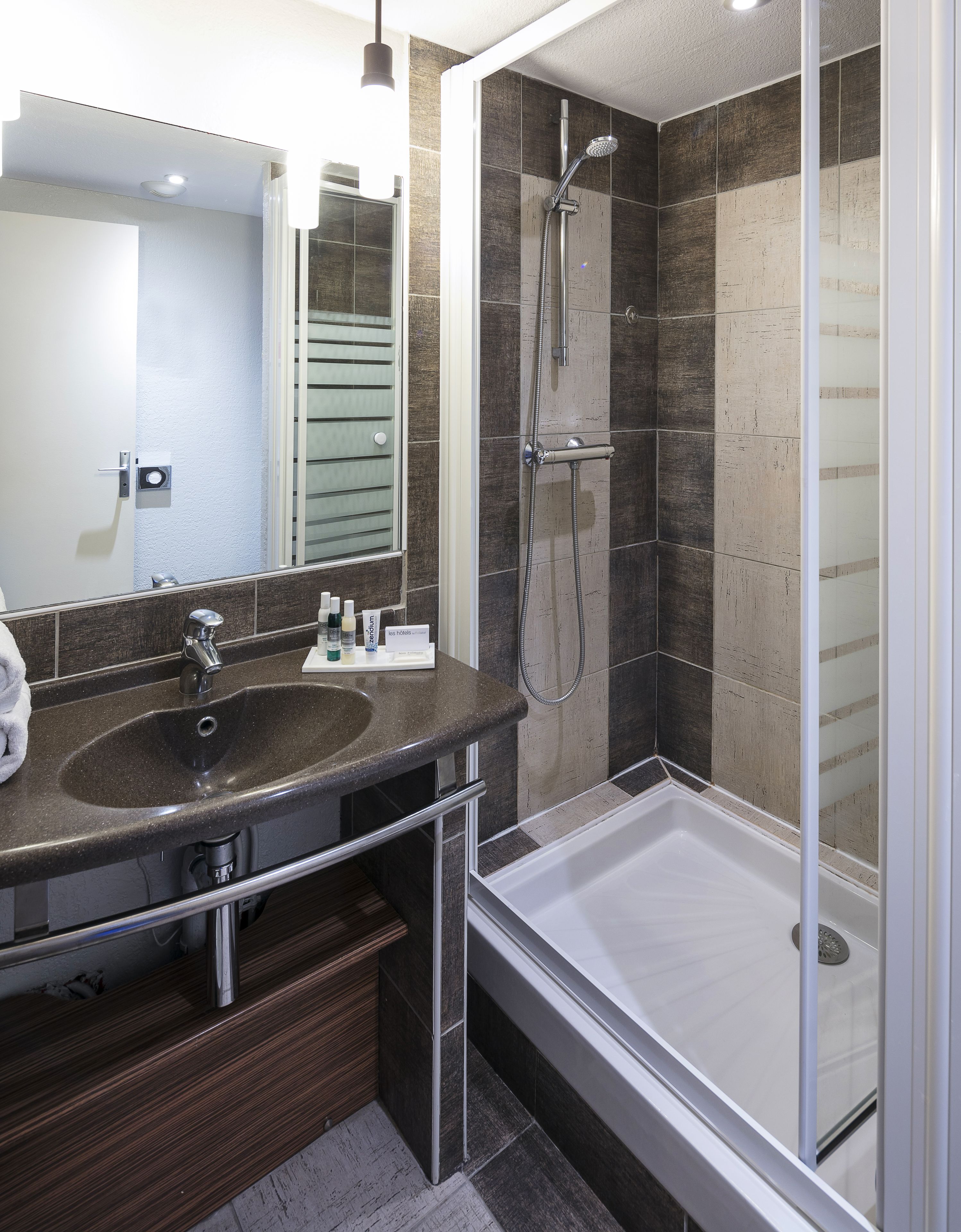 Ein modernes Badezimmer mit Waschbecken, Spiegel und Dusche.