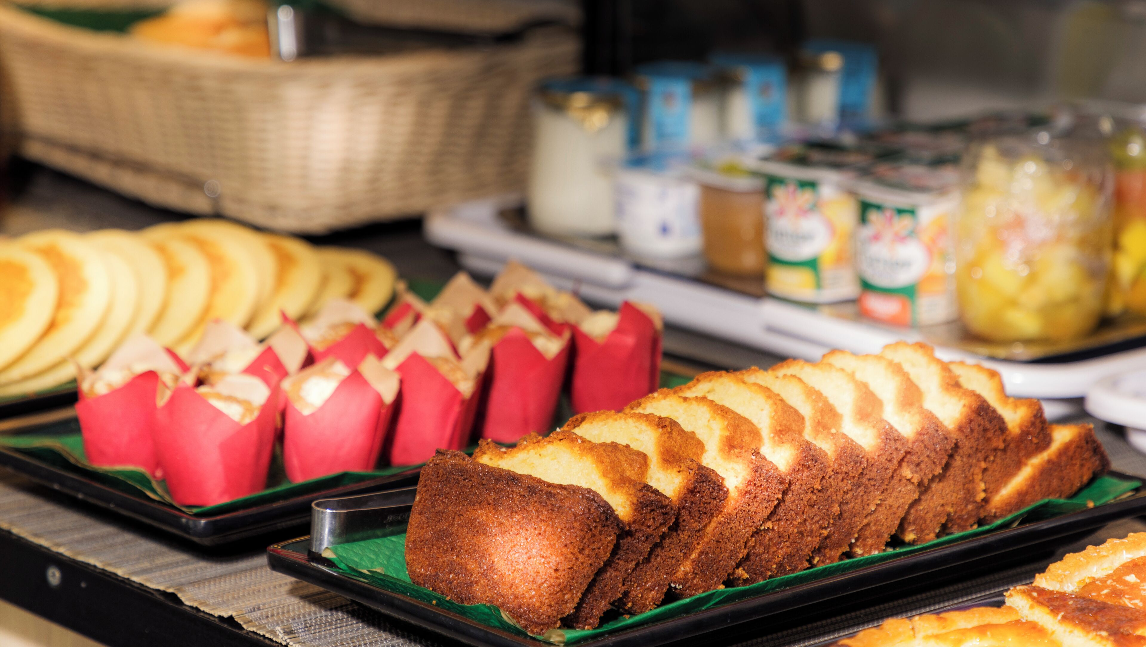 A buffet with various food items including bread, pastries, and condiments.
