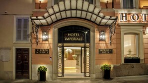 Exterior del Hotel Imperial, con una entrada imponente, puertas dobles y un cartel sobre ellas.
