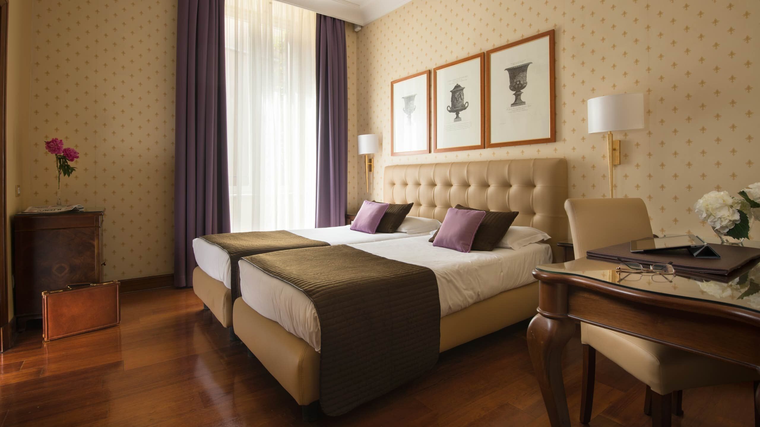 Habitación de hotel con una cama grande, dos mesitas de noche, un escritorio y una silla.