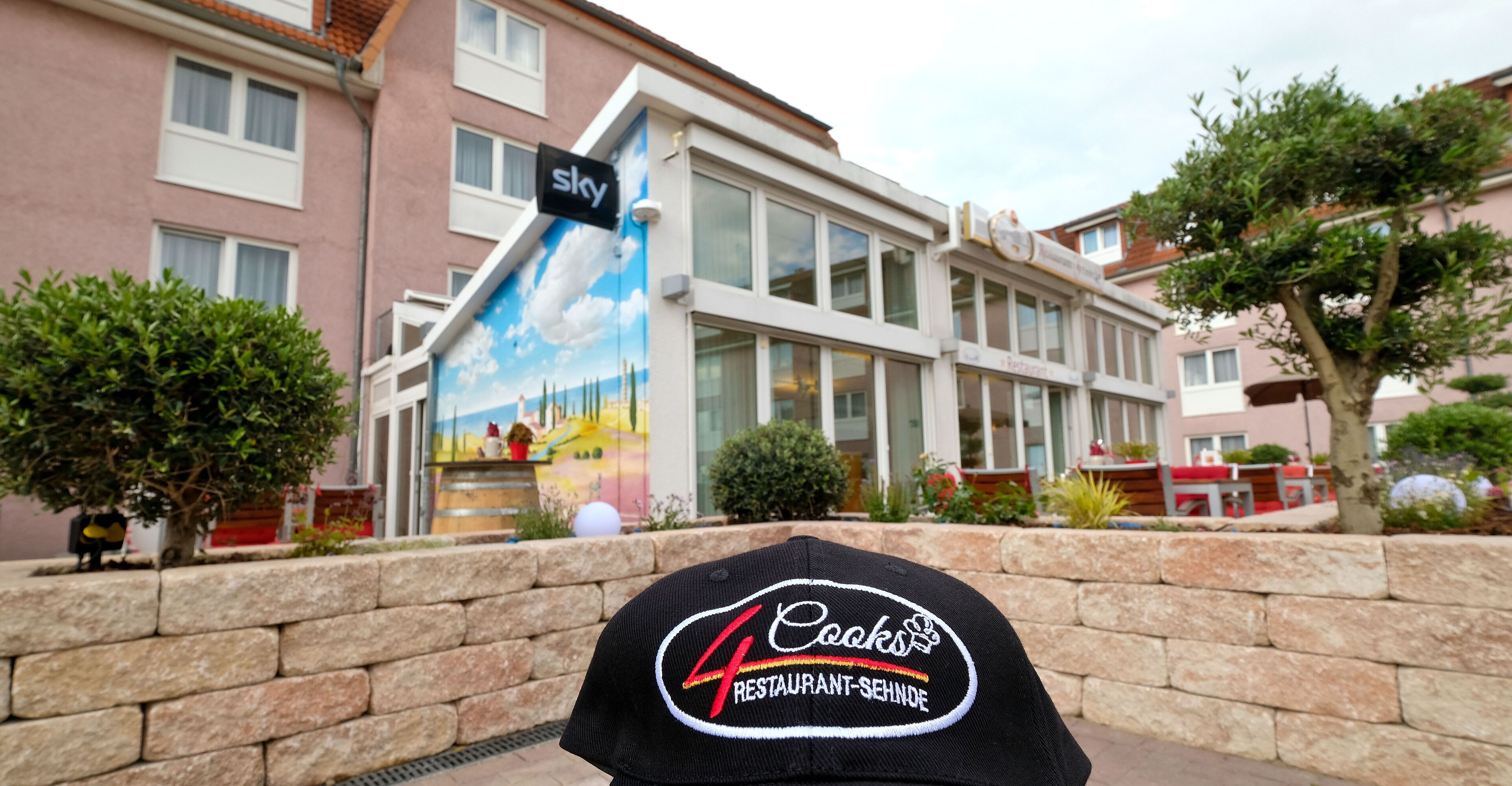 A building with a 'sky' sign and a 'Cooks Restaurant' sign.