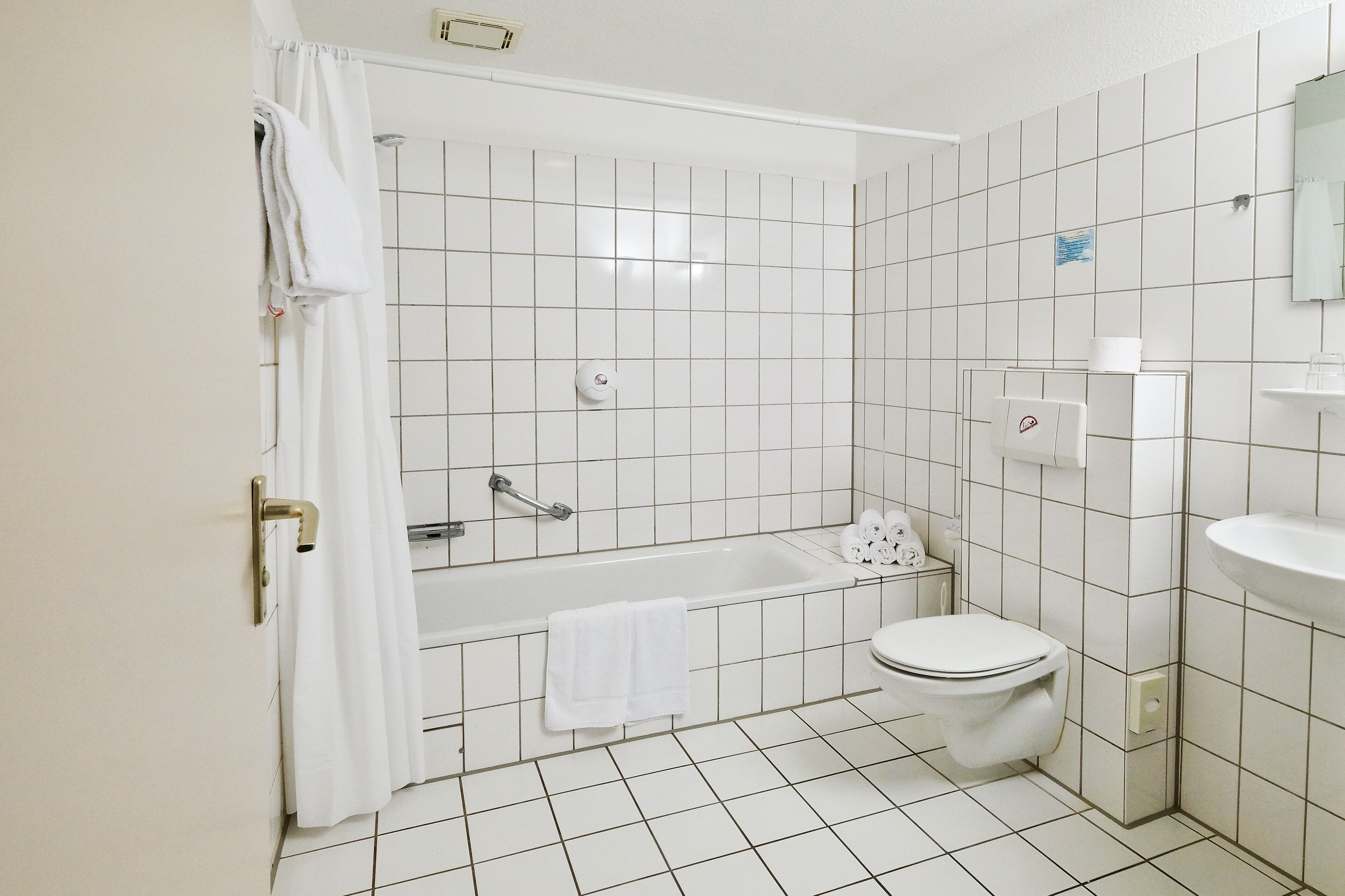 A bathroom with a bathtub, toilet, and sink, all in white.