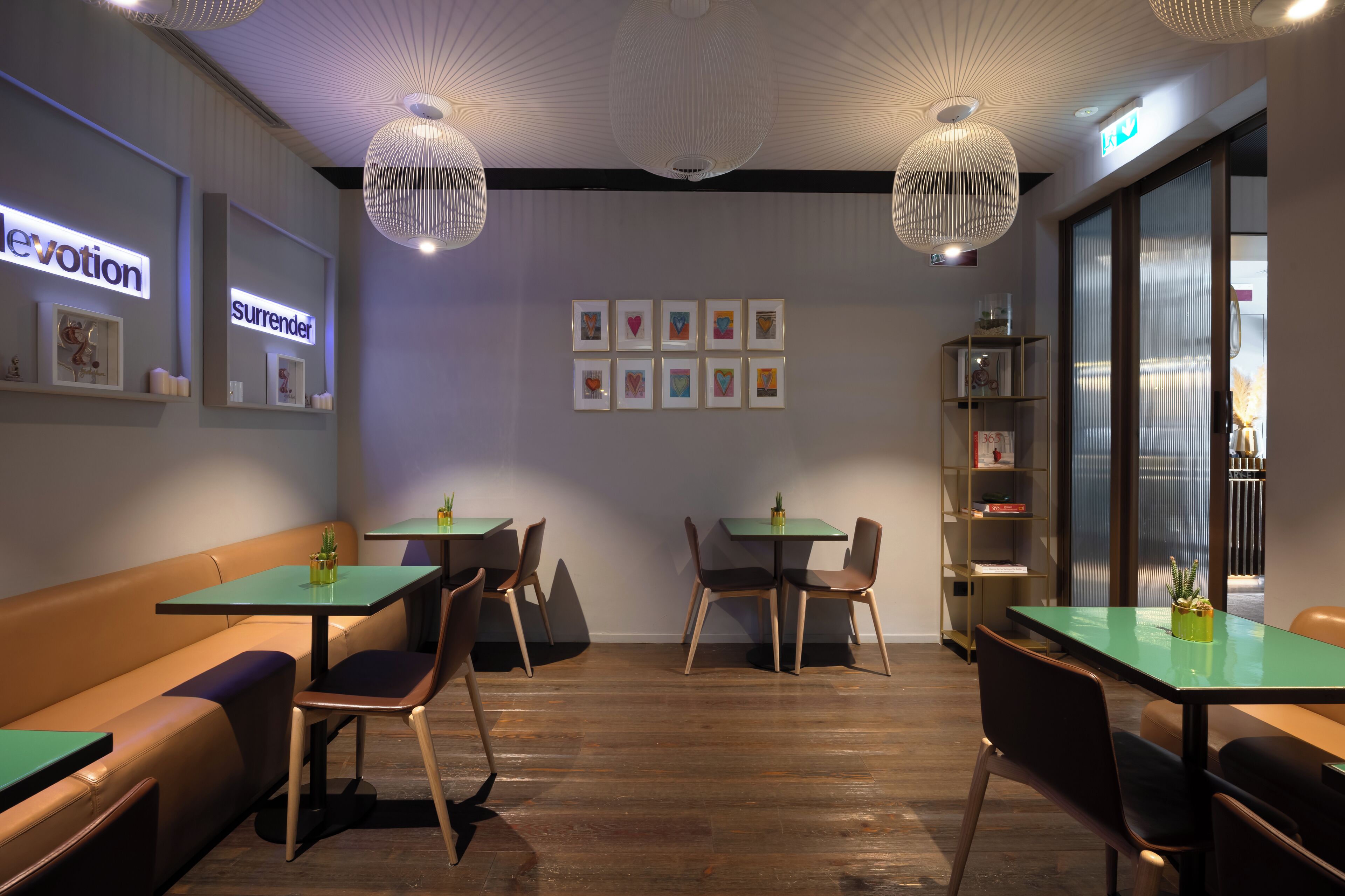 A modern interior with a seating area, tables, and a bookshelf.