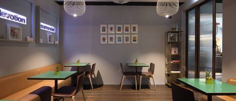 A modern interior with a seating area, tables, and a bookshelf.