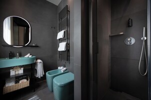 Un baño moderno con un espejo grande, dos lavamanos, ducha y toallero.