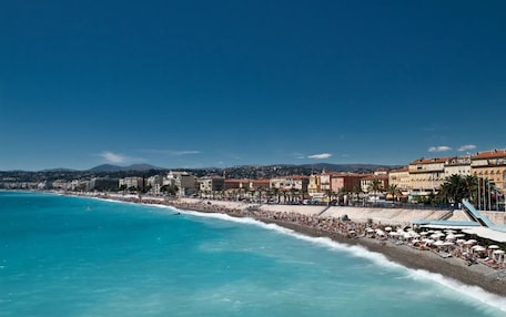 A coastal cityscape with a beach, buildings, and clear skies.