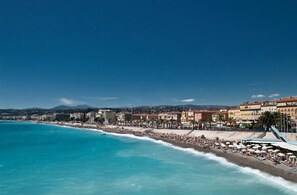 Un paisaje urbano costero con playa, edificios y cielos despejados.