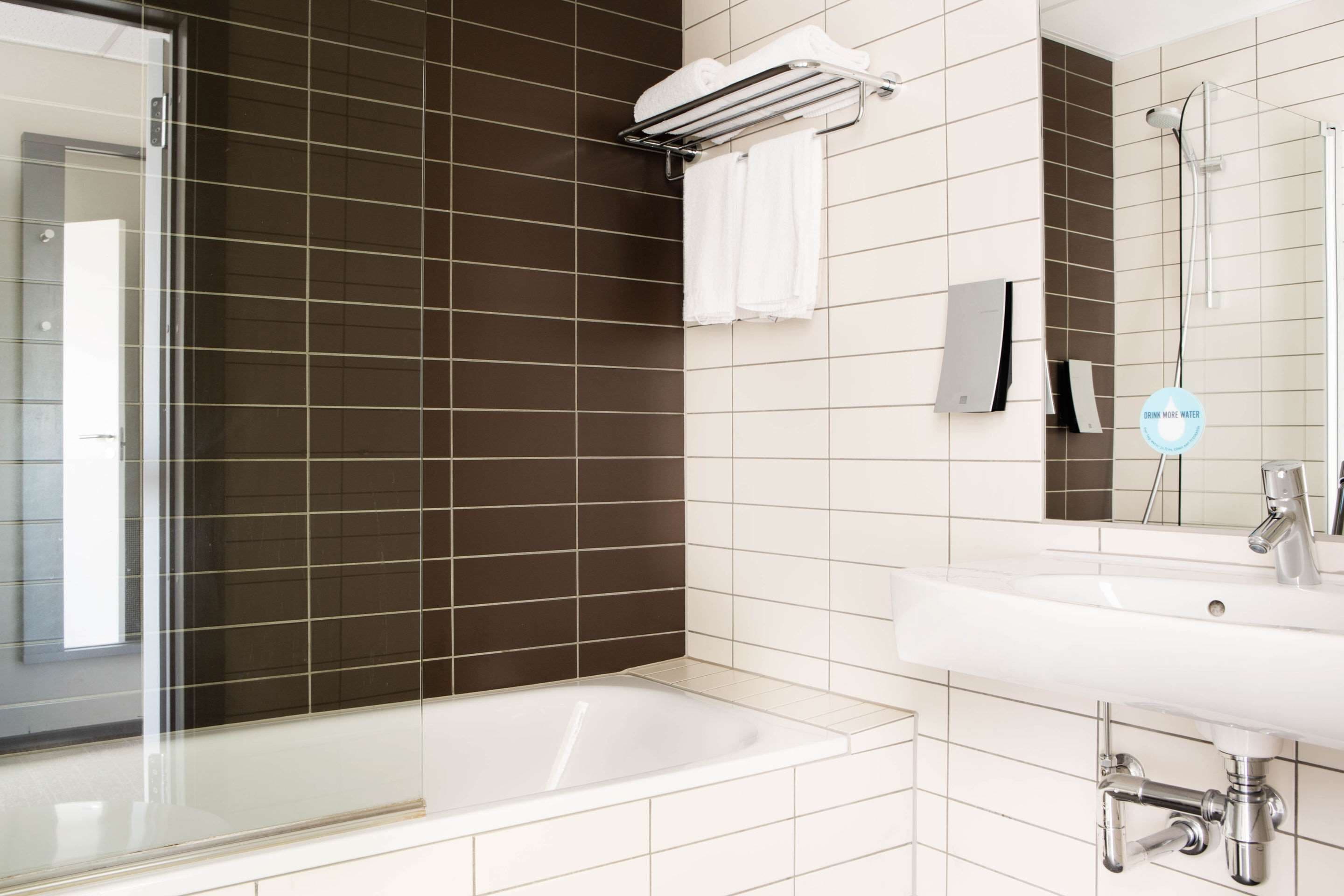 Un baño moderno con bañera, lavamanos y ducha.