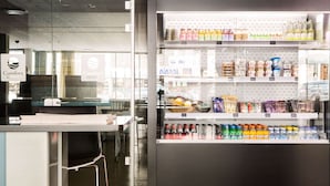 A hotel lobby with a reception desk, a vending machine stocked with beverages, and a view of the street outside. - Comfort Hotel Kristiansand (Kristiansand)
