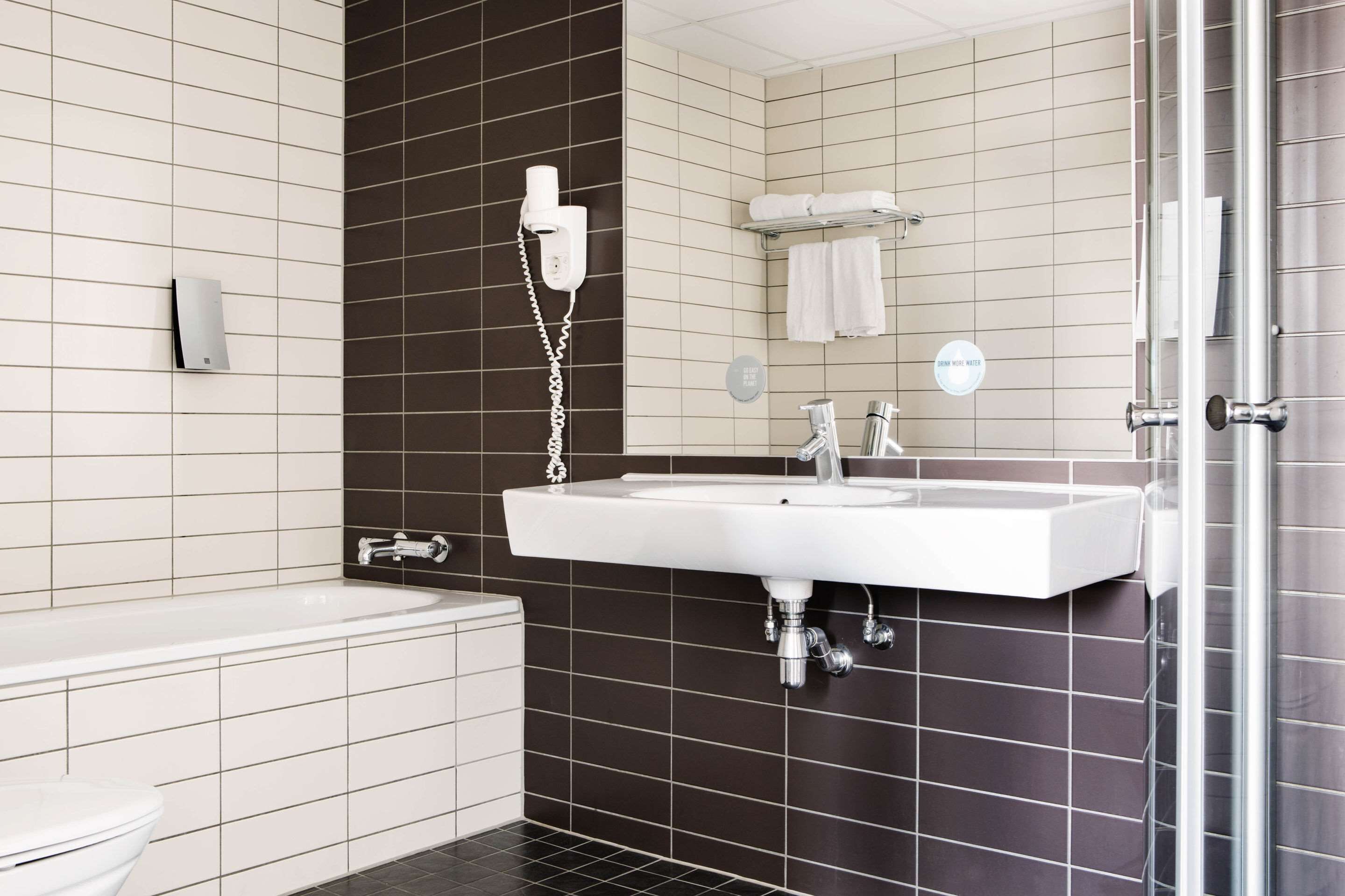 A modern bathroom with a bathtub, a sink, and a toilet.
