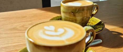 Two cups of coffee on a table with saucers.