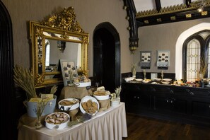 Montaje de bufé con diversos alimentos y un espejo grande y ornamentado.