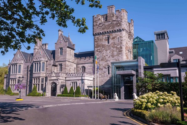 Un edificio histórico con una torre destacada y una extensión de vidrio moderna.