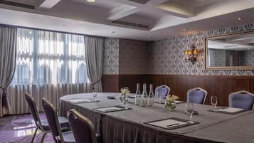 A conference room with a long table, chairs, and a chandelier.