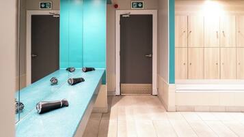 A bathroom with a mirror, a sink, and a towel rack.