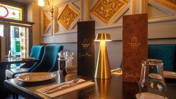 A restaurant setting with a table set for dining, a wine menu, and a reservation sign.