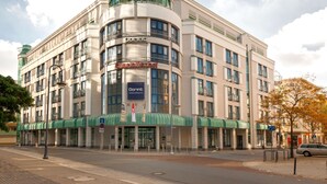 A large, multi-story hotel with a distinctive green dome and a curved facade.