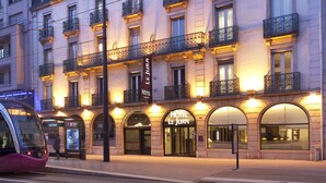 Un hotel con varios balcones, una entrada destacada y un letrero que indica que es un establecimiento de 4 estrellas.