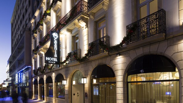 A hotel facade with arched windows, a prominent sign, and a balcony with decorative railings. - Hôtel Oceania Le Jura Dijon (Dijon)