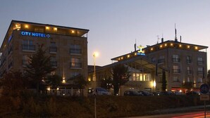 A CITY HOTEL with a prominent sign, multiple floors, and a parking area. - City Hotel Frankfurt am Main Bad Vilbel (Bad Vilbel)