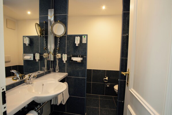 Un baño moderno con un lavabo blanco, un espejo y un inodoro.