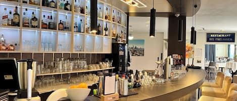 A bar area with shelves of liquor bottles, glasses, and a counter with a menu stand.