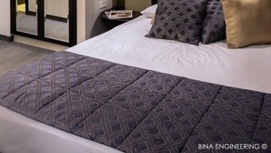 A hotel room with a bed, a nightstand, a framed artwork on the wall, and a door leading to a bathroom. - The Golden Walls Hotel (Jerusalem)