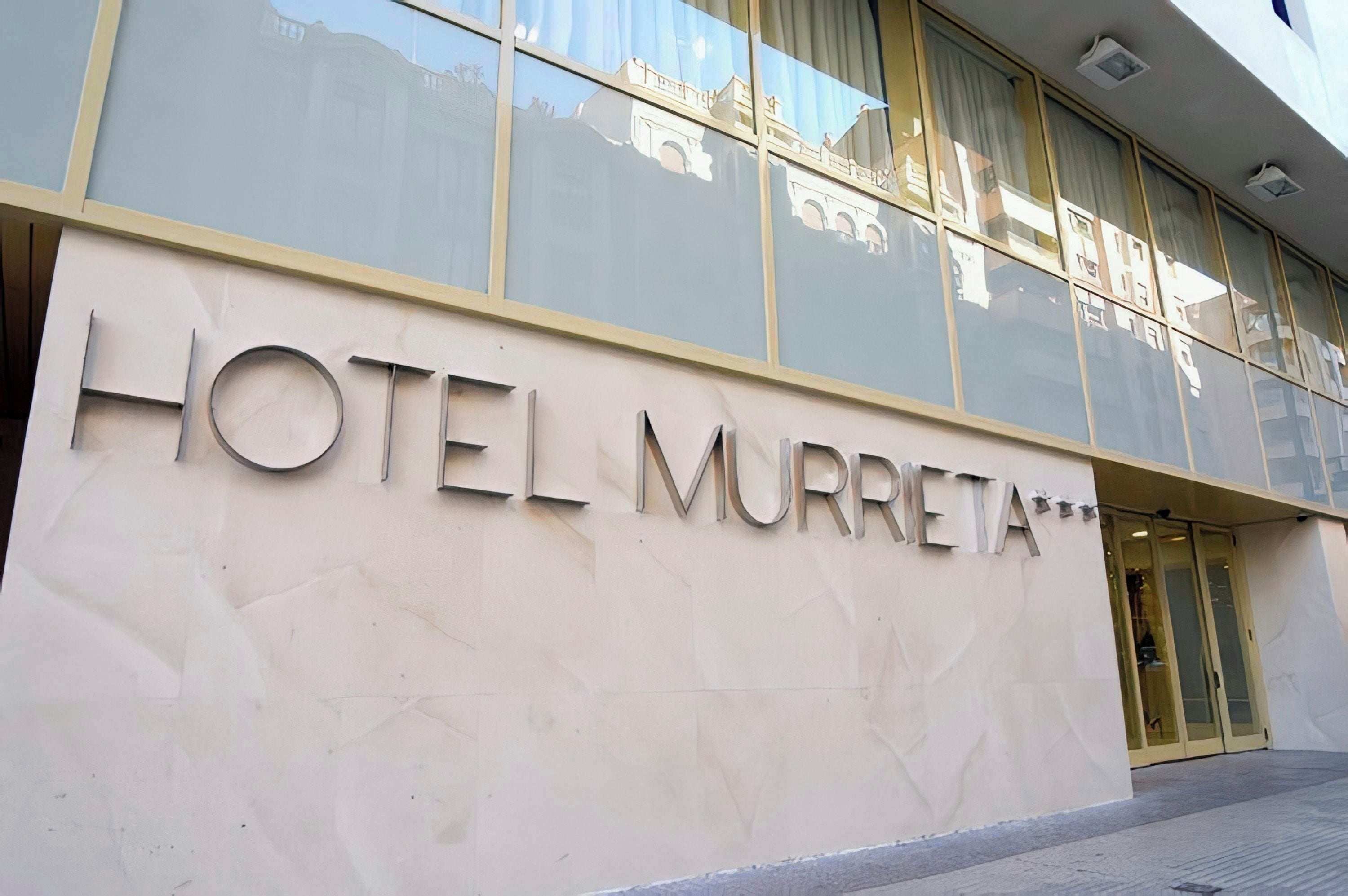 Entrada de un hotel con un cartel grande que dice 'HOTEL MURRETA'.